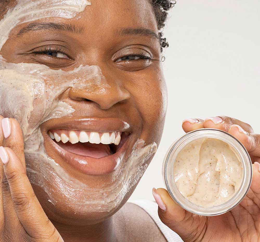 A woman holding Finely Awake cleansing face scrub.