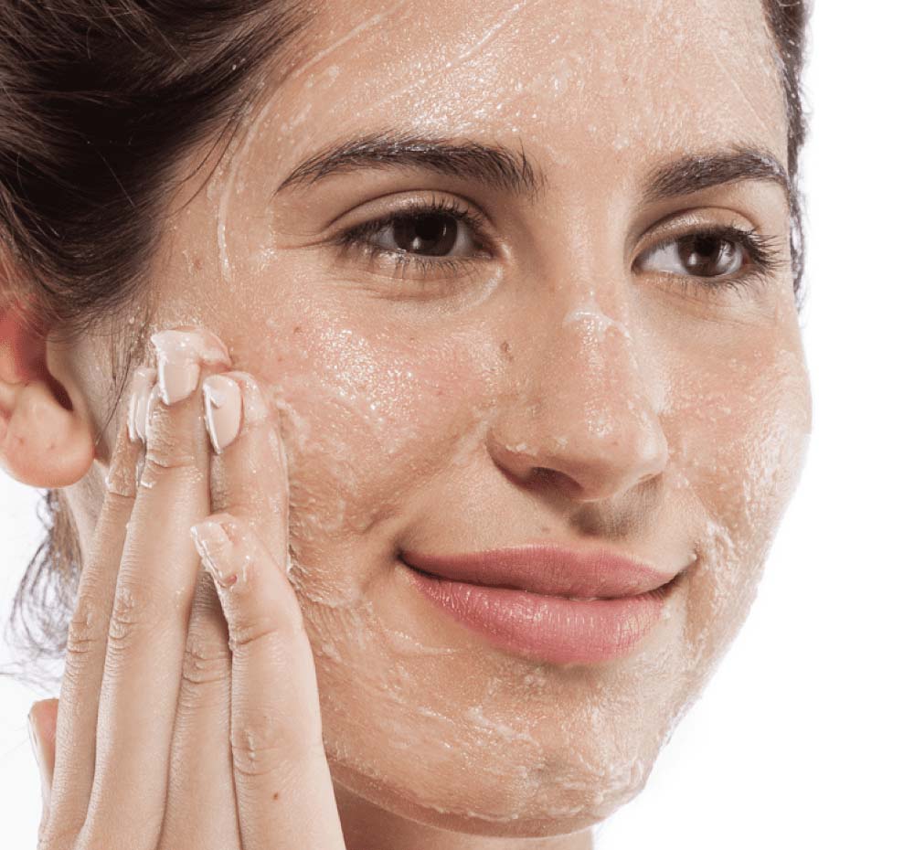 A woman exfoliating her face with Finely Awake daily exfoliating cleanser.