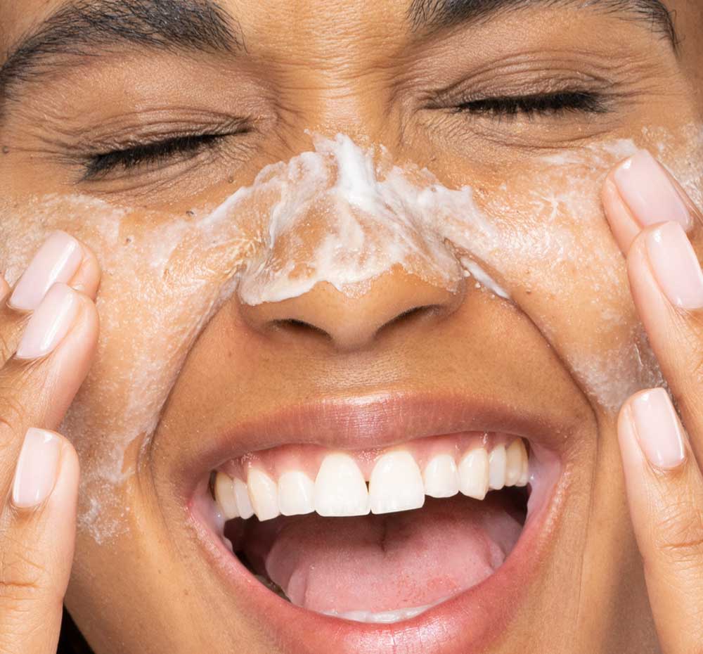Woman applying Timescape renewing face polish.